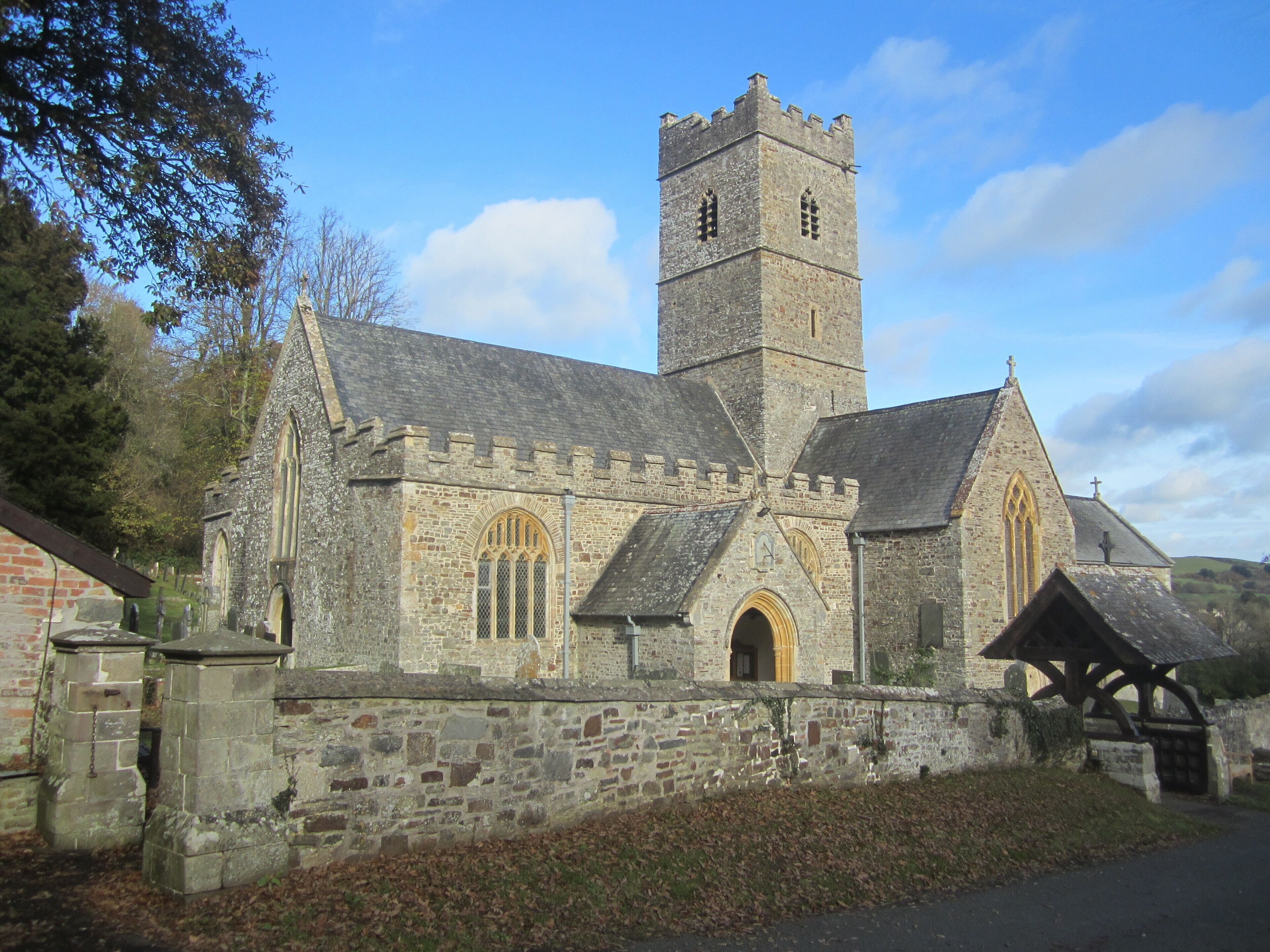 A historic stone church with a tall tower and arched windows.
