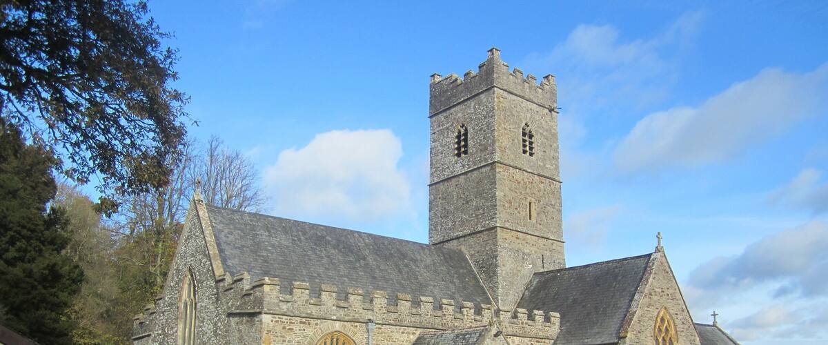A historic stone church with a tall tower and arched windows.