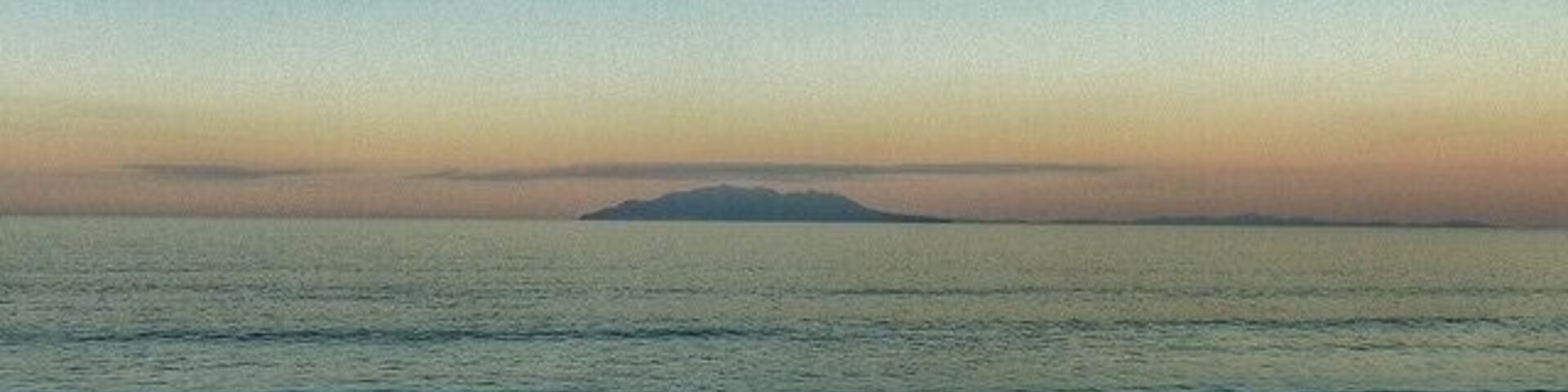 Uma praia com dunas de areia e mar calmo.