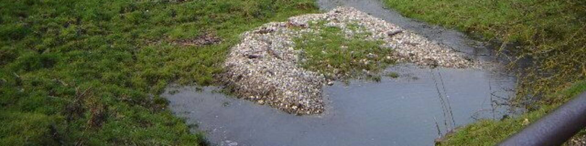 Haw Bridge near Holybourne. This is a little winterbourne feeding the River Wey which goes under the bridge in the middle. You may be able to just make out the Holybourne oil loading depot in the background.