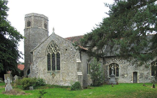 A historic stone church with a bell tower and arched windows.