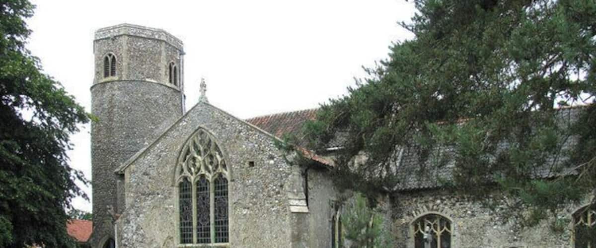 A historic stone church with a bell tower and arched windows.