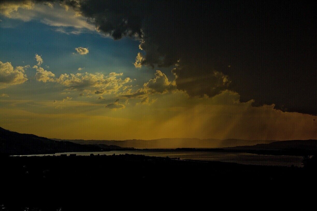 A sunset over a body of water with distant mountains.