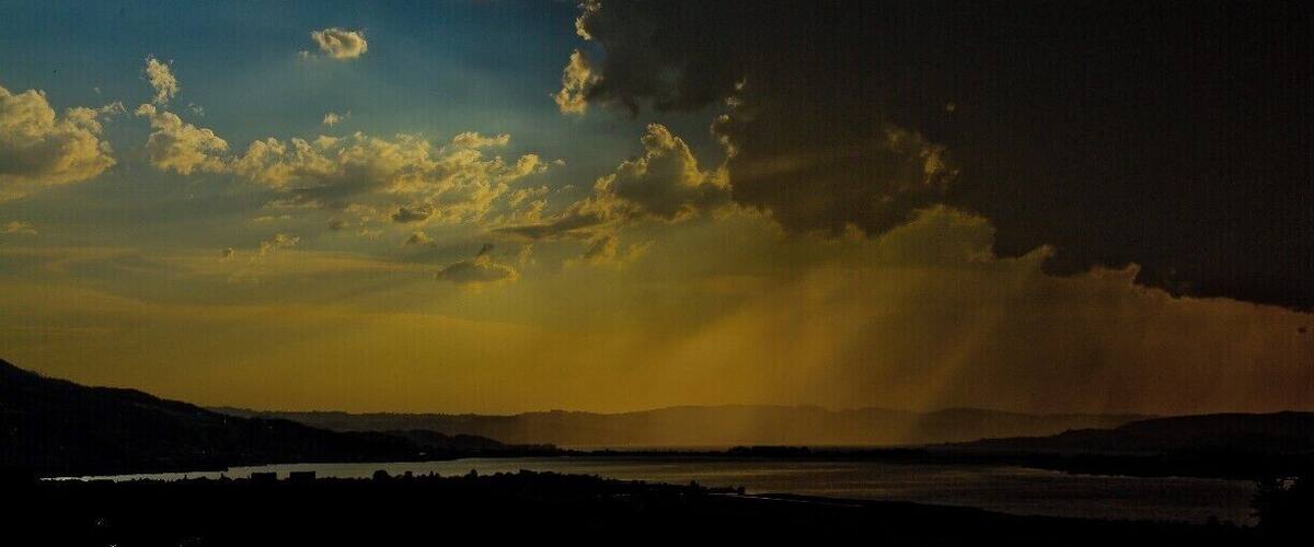 A sunset over a body of water with distant mountains.