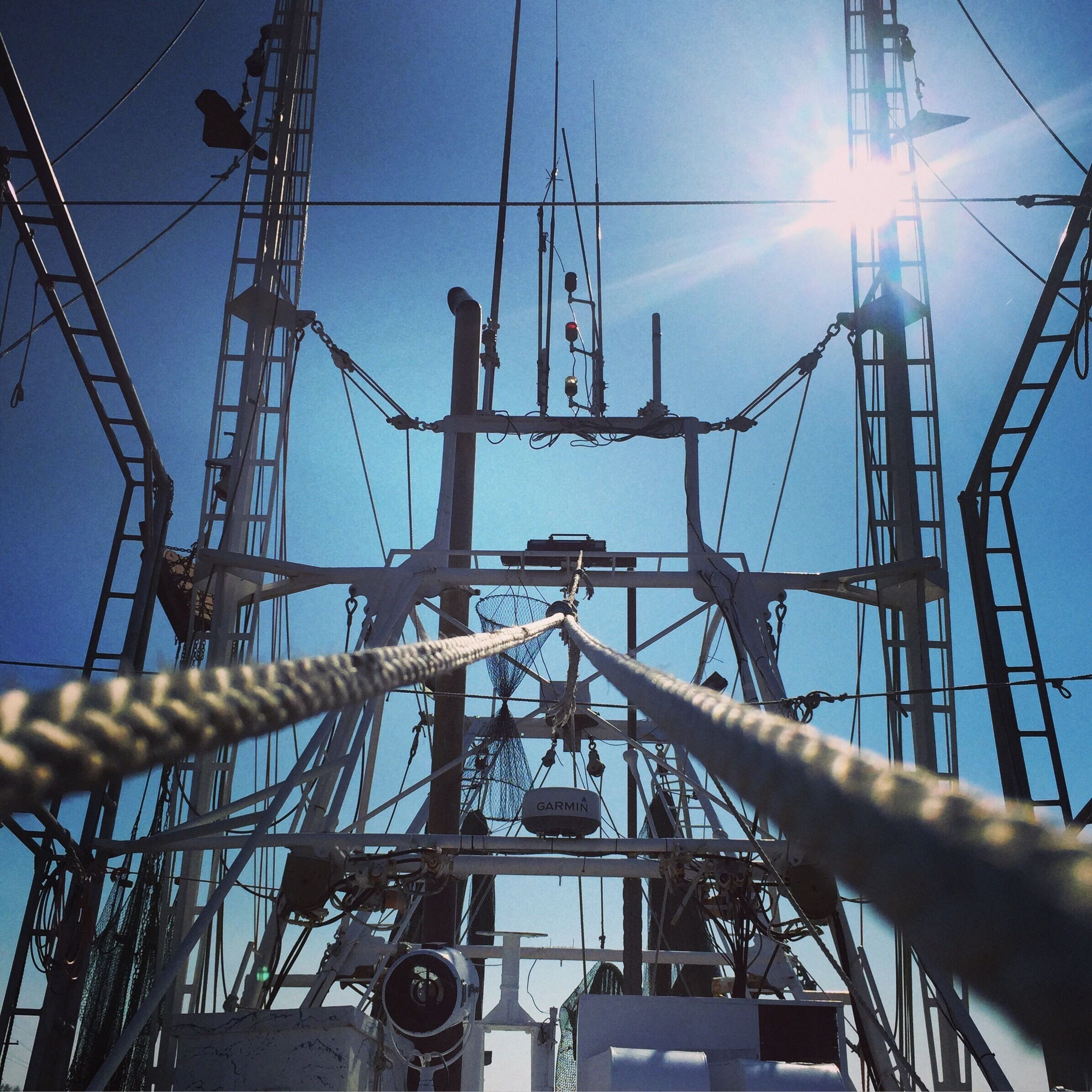 A complex network of metal structures and cables against a clear blue sky.