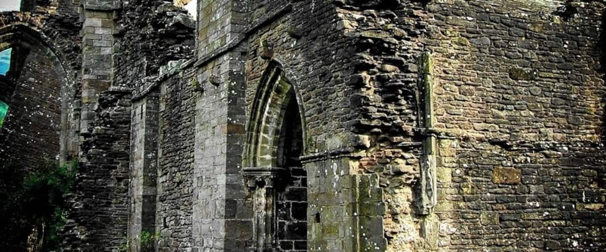 A historic stone building with arched windows and a large central doorway.