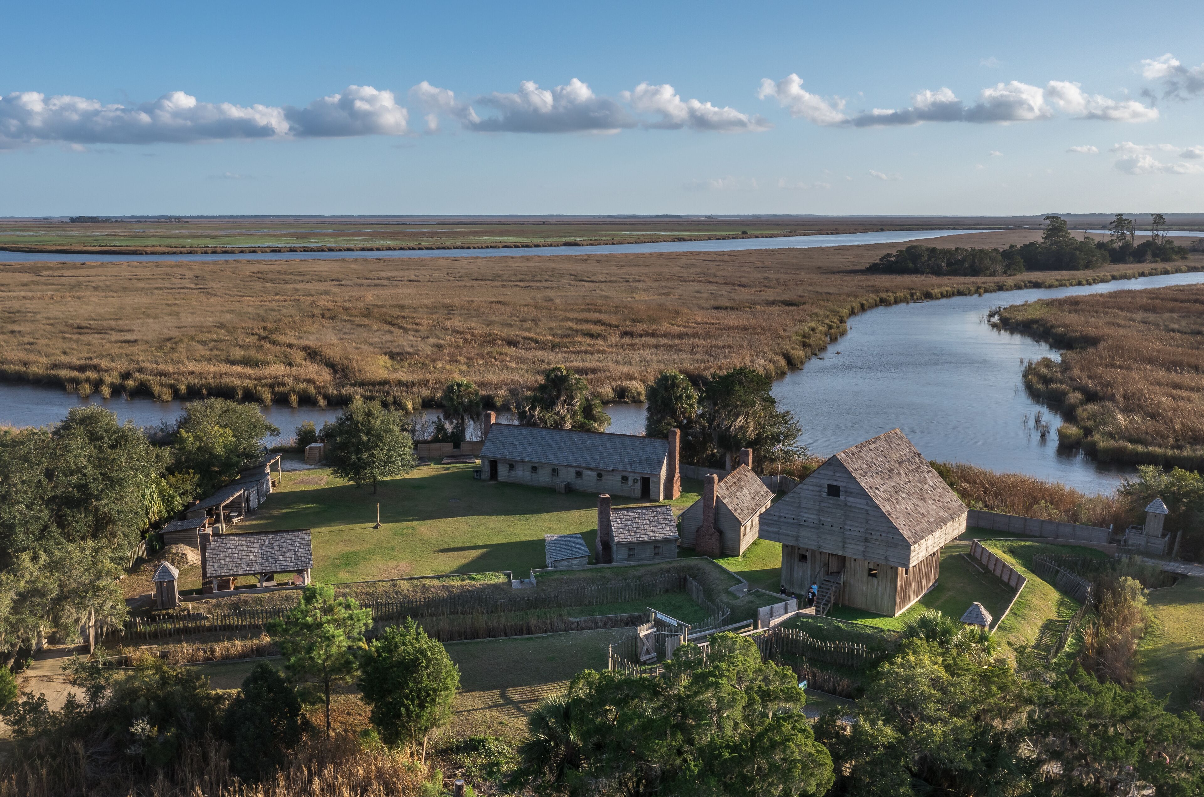 Aerial view of Fort King George historic site, oldest English fort on the Georgia coast from the 17th century with wooden palisade, gun ports for cannons blue cloudy sky near Darien Georgia USA