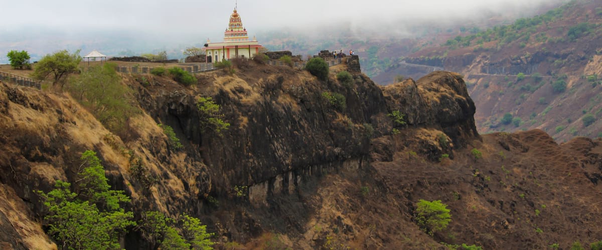 A temple on a cliff with a misty background.