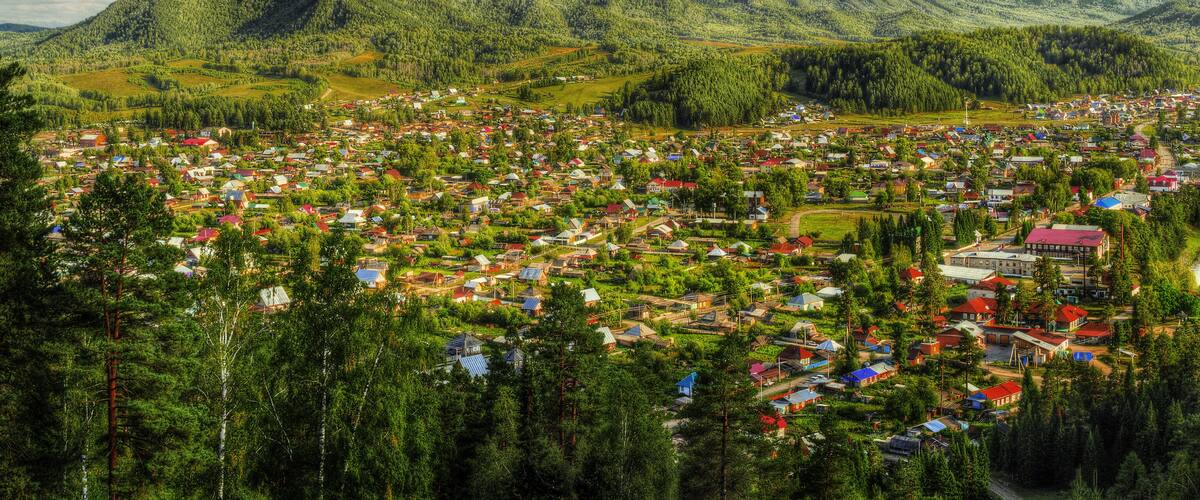 A town nestled in a valley surrounded by mountains, with a mix of residential and commercial buildings.