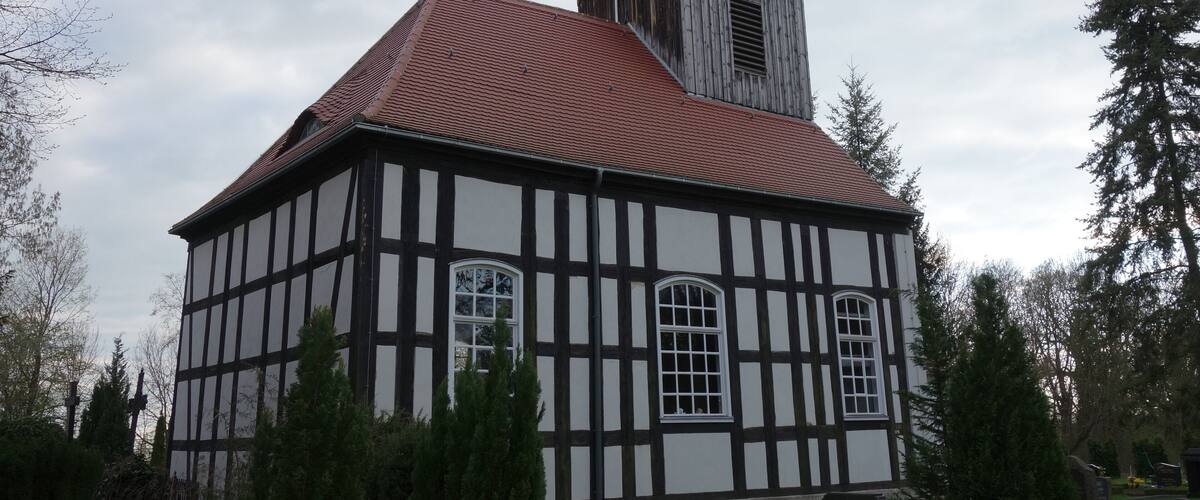 A half-timbered building with a red-tiled roof and a small tower with a golden ornament.