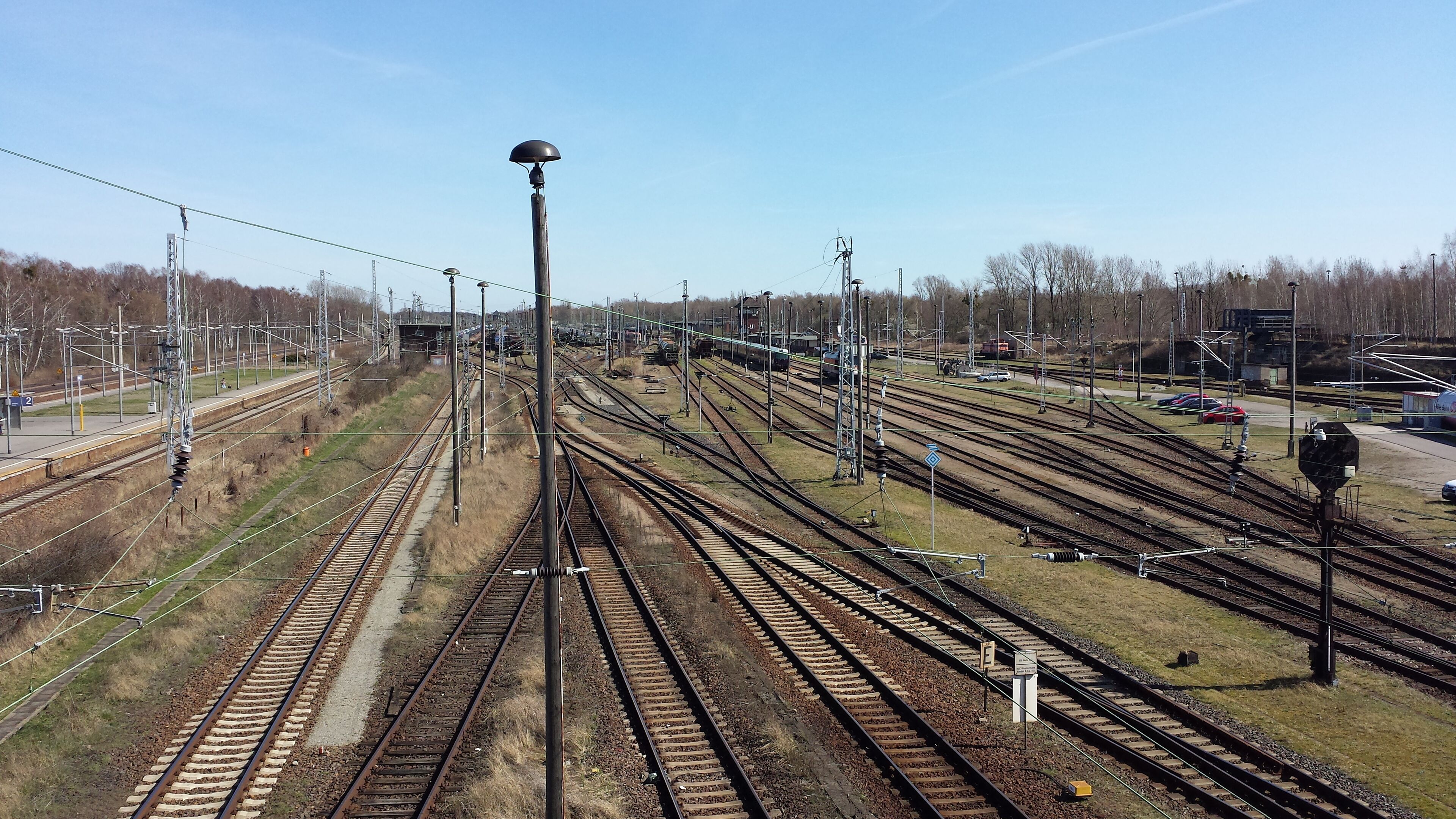 A complex railway yard with multiple tracks and overhead electrical lines.