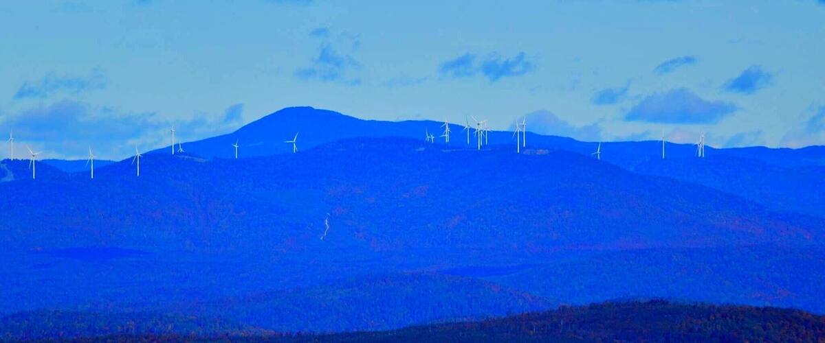A mountain range with wind turbines.