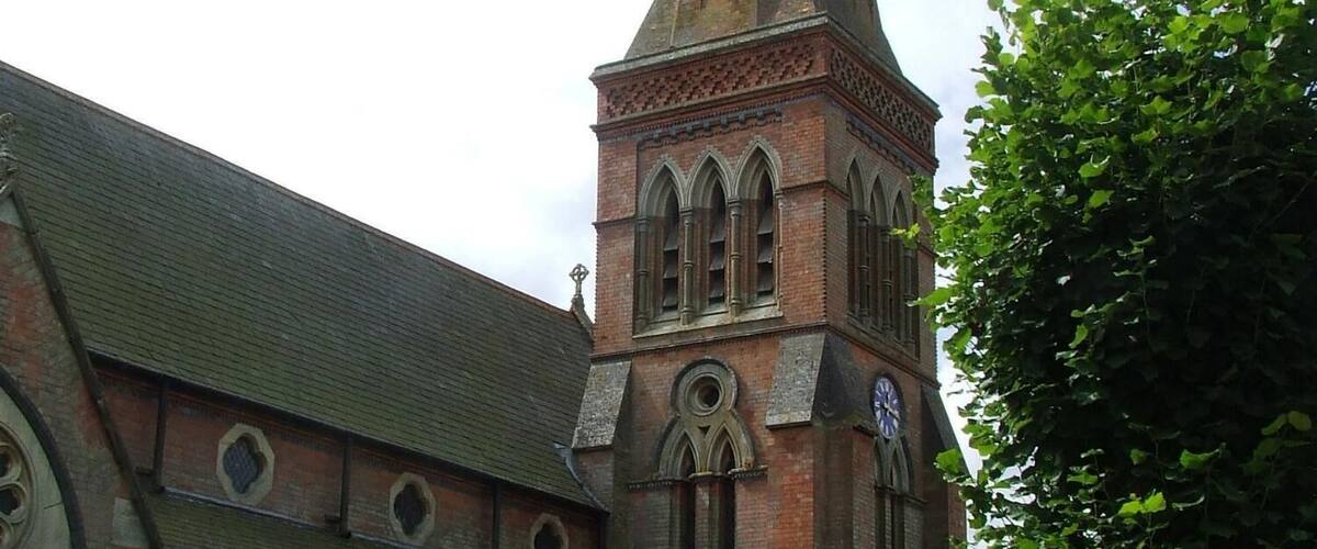 A historic church with a tall spire and arched windows.
