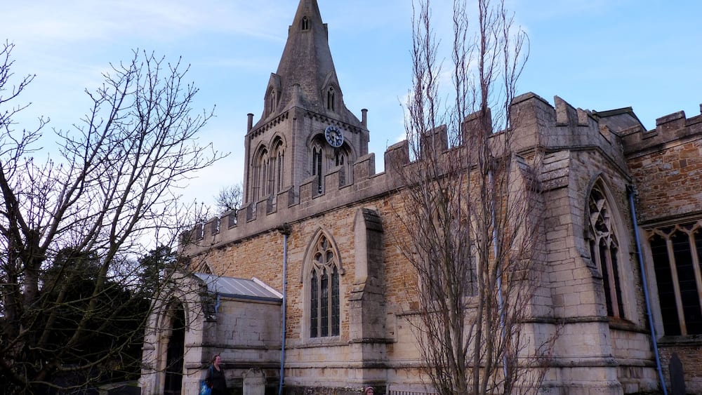 Une église historique dotée d’un clocher imposant et de fenêtres en arc de cercle.