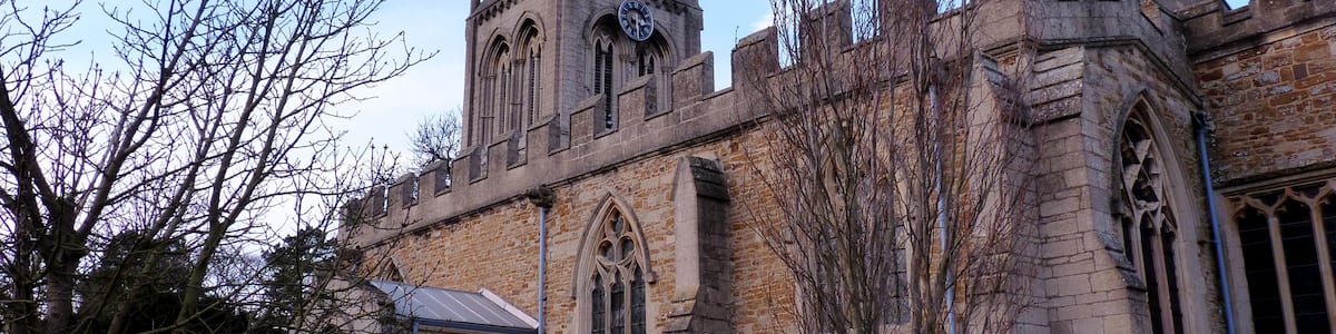 Eine historische Kirche mit einem hohen Turm und Rundbogenfenstern.