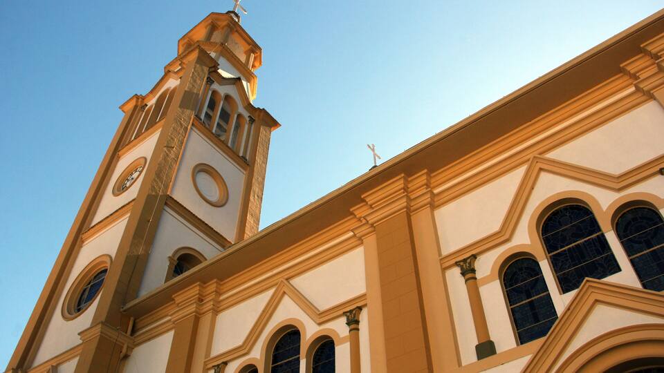 A church with a bell tower, arched windows, and a clock.
