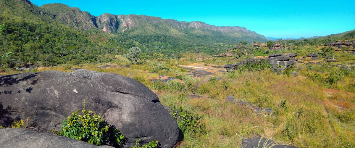 A mountainous landscape with green vegetation and large rocks.