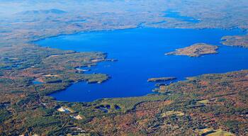 A large body of water surrounded by forested areas and distant mountains.