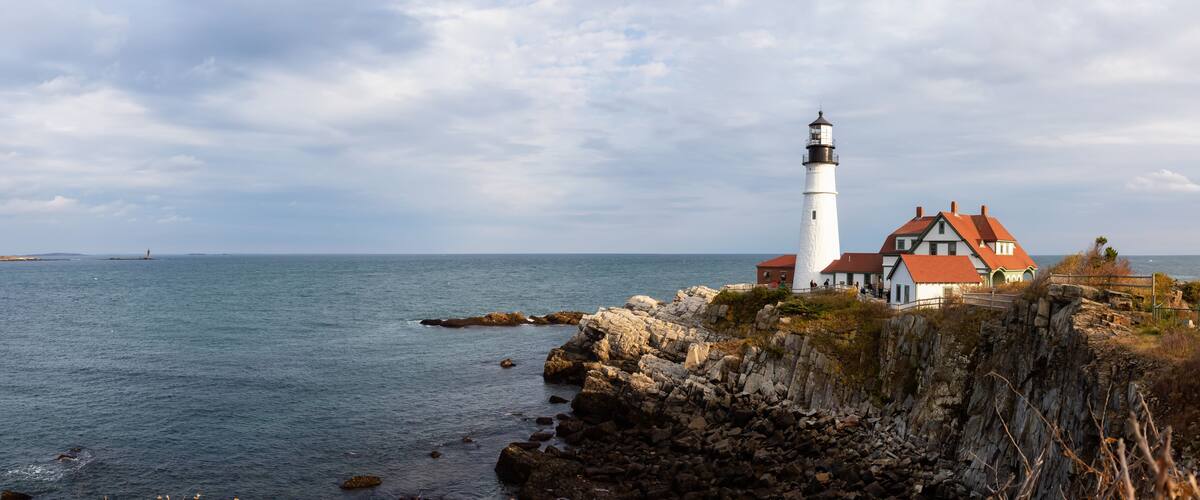 A lighthouse and a house by the sea.