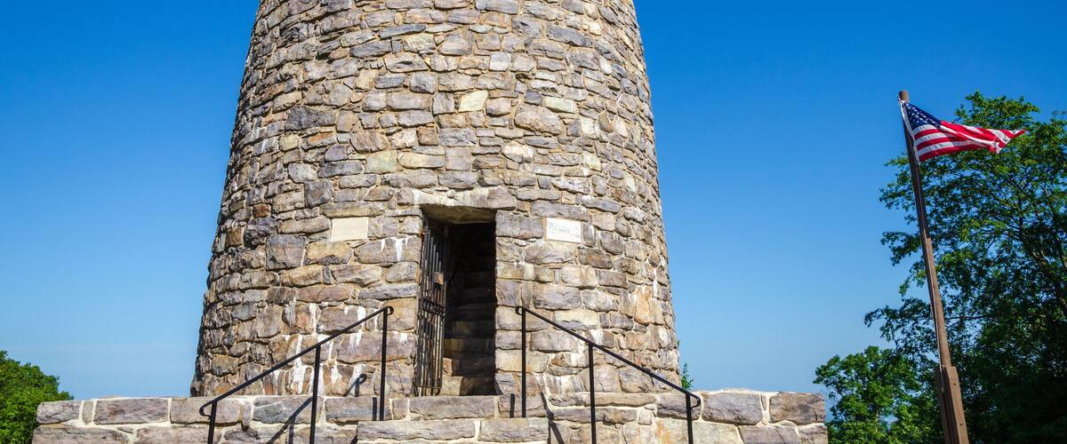 A stone tower with a flagpole and an American flag.