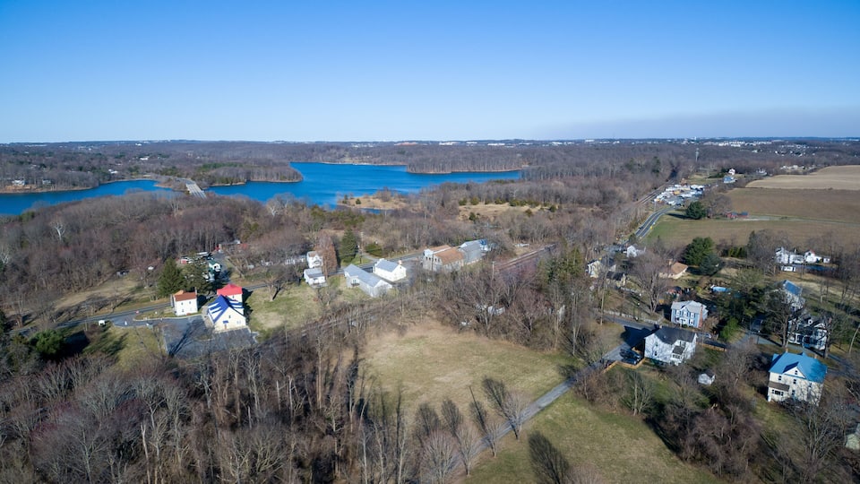 An aerial view of a lakeside community with houses, roads, and a dam.