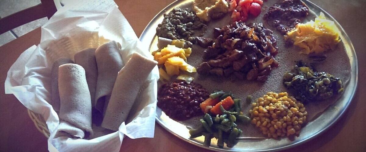 A plate of Ethiopian cuisine with injera, lentils, and vegetables.
