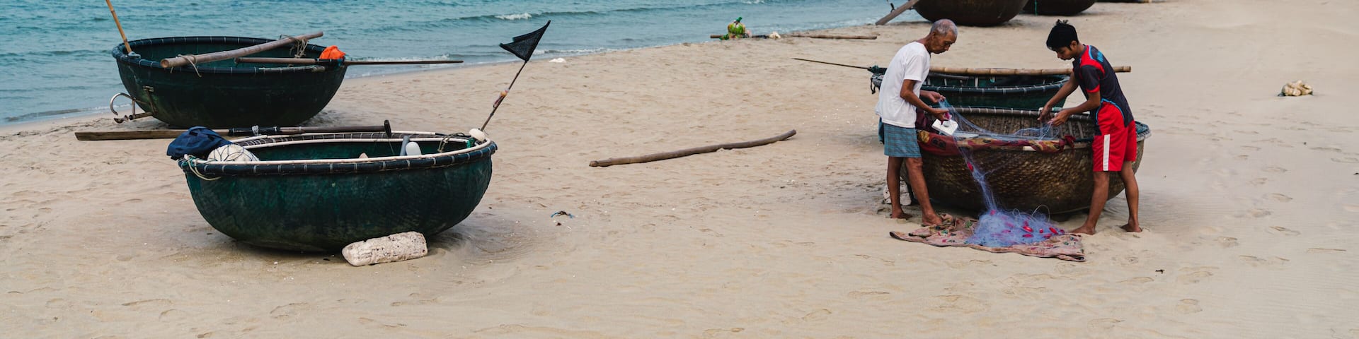 father and son dealing with fishnet, vietnam