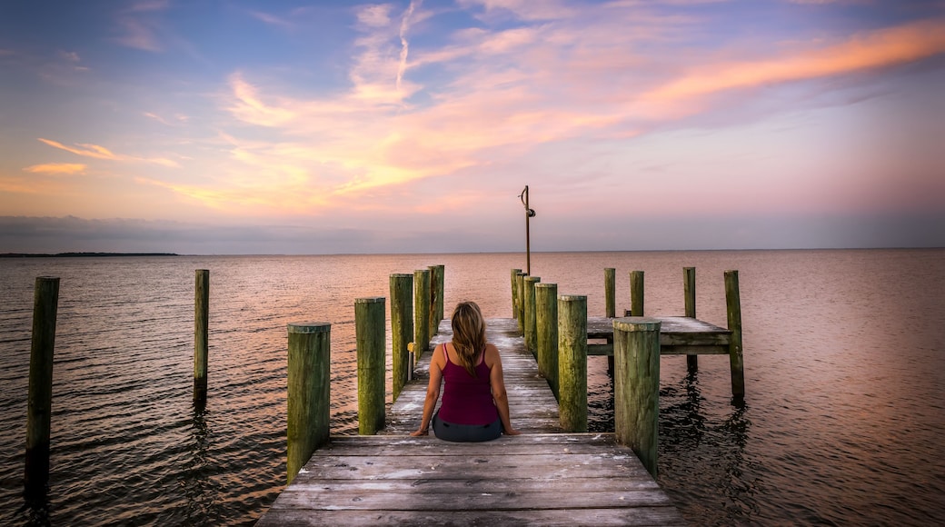 Woman watching a sunset from a pier on the Chesapeake bay in Maryland