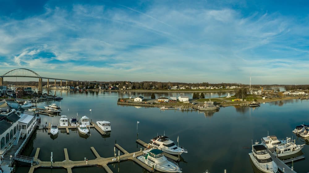 Aerial panorama of Chesapeake City Maryland historic fishing town on the Chesapeake Delaware canal with private boats docked in the marina and the Chesapeake City Bridge over the back creek