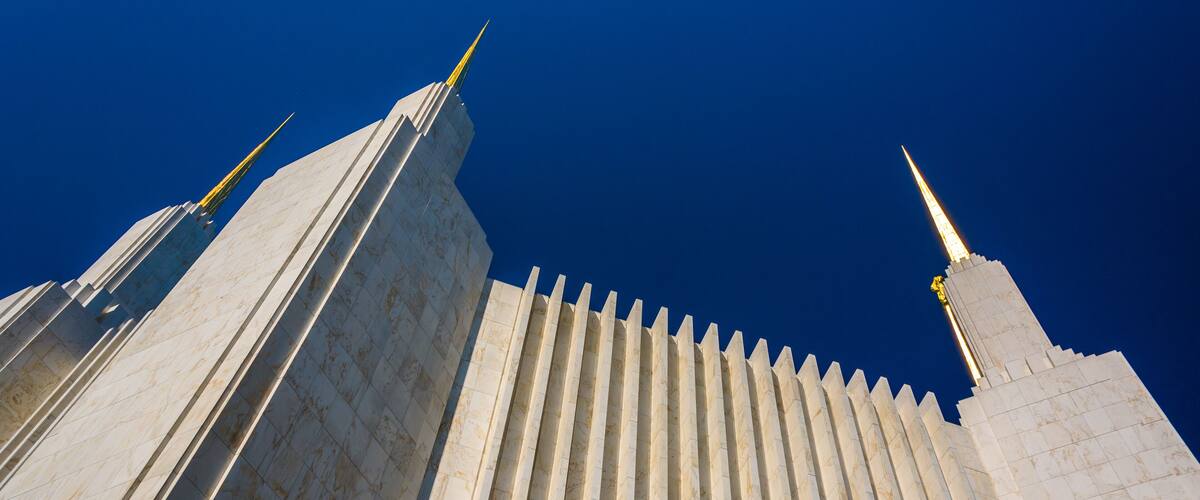 A tall, white building with vertical lines and pointed spires.