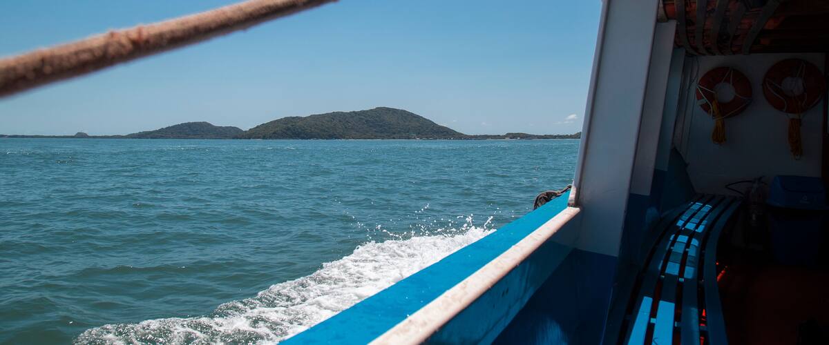 A boat on a calm sea with a clear sky and distant land.