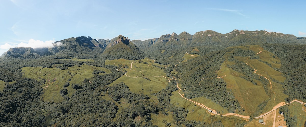A mountainous landscape with dense forests and winding paths.