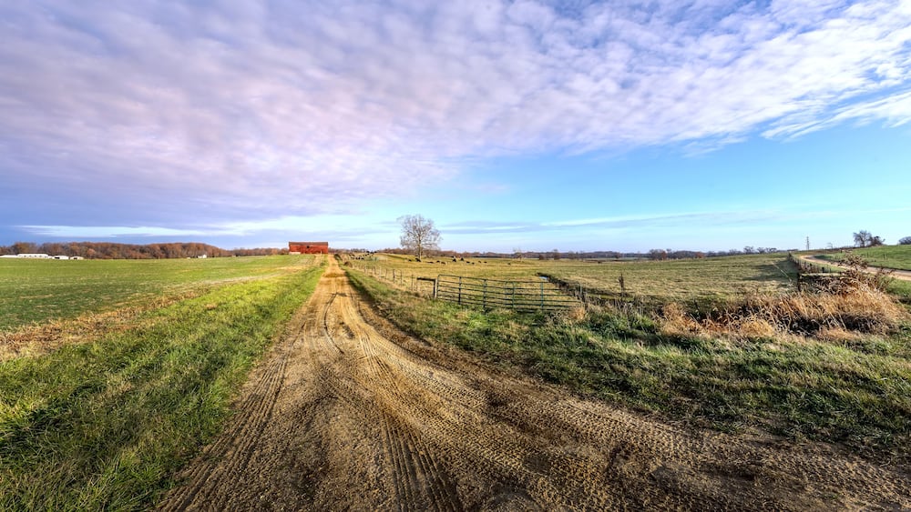 Rural Maryland Farm Landscape with long Dirt Road leading to a Red Barn