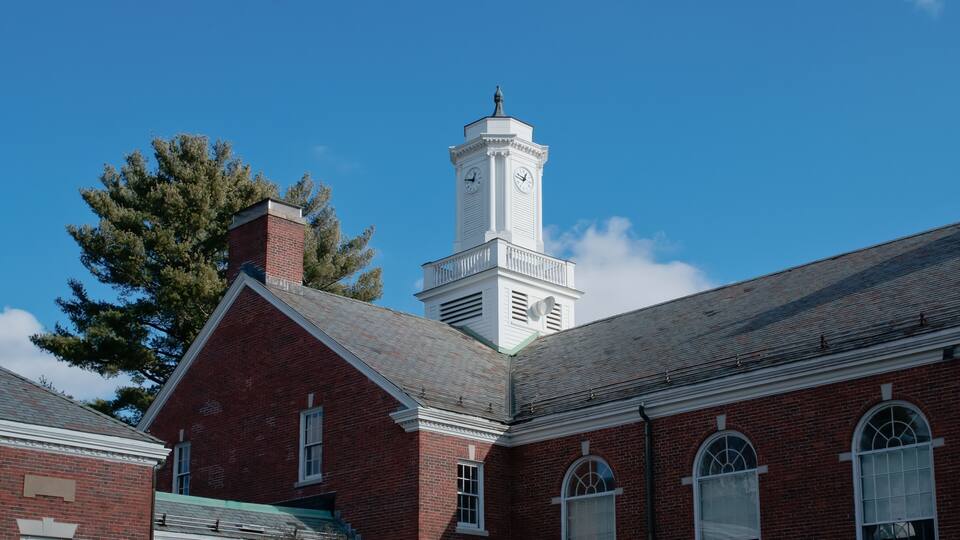 A red brick building with a white clock tower.