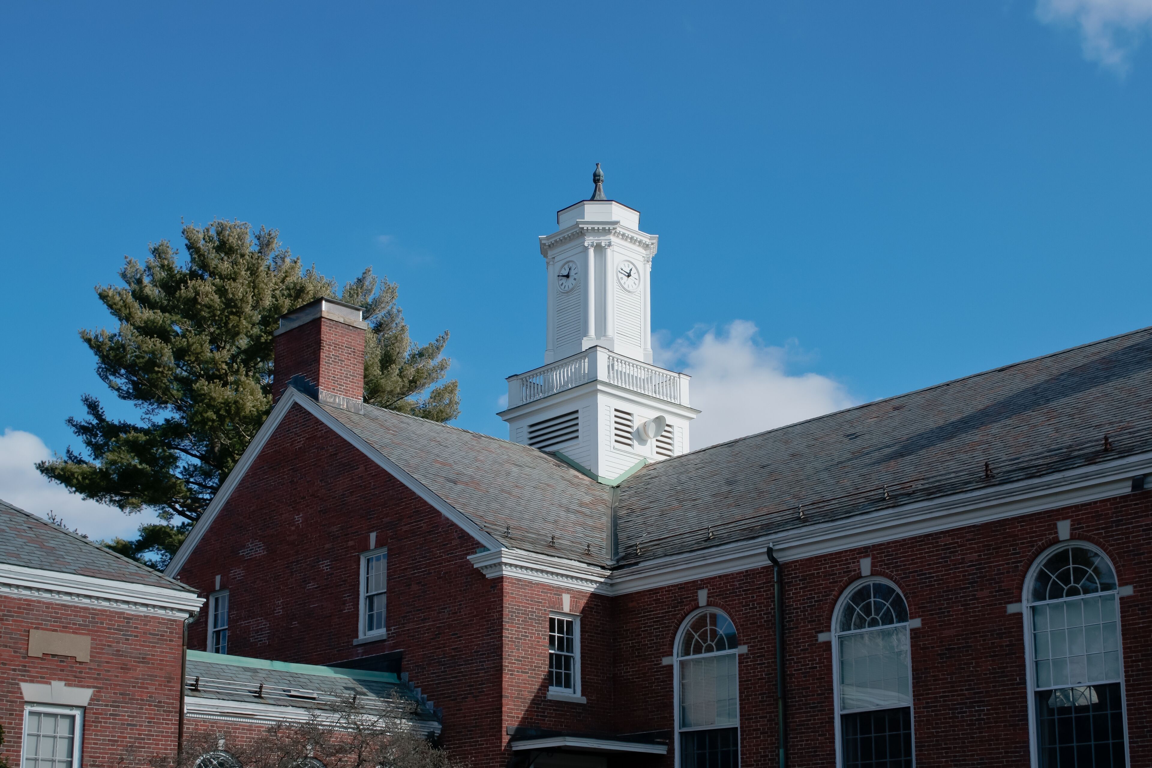 A red brick building with a white clock tower.