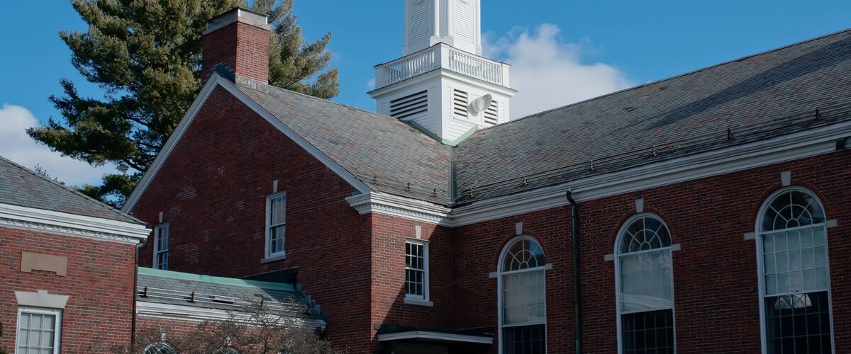 A red brick building with a white clock tower.