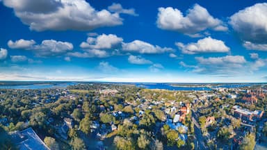 An aerial view of a coastal town with dense residential areas, a prominent church, and a large body of water in the background.