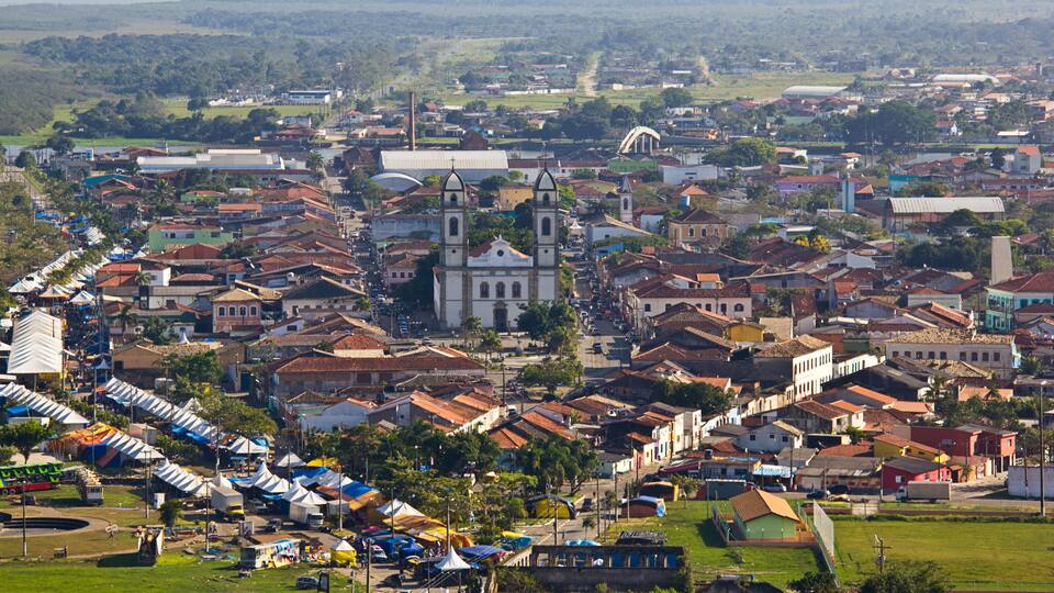 A town with a prominent church, colorful buildings, and a green park area.