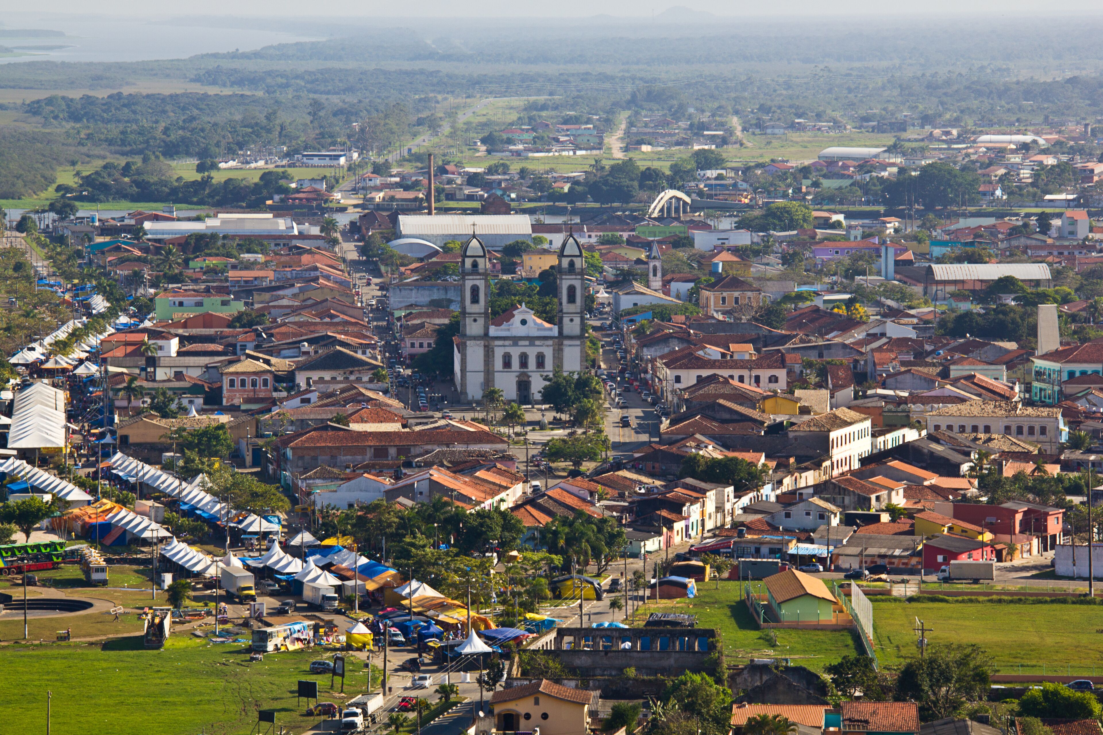 A town with a prominent church, colorful buildings, and a green park area.