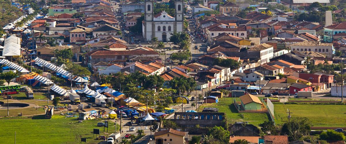A town with a prominent church, colorful buildings, and a green park area.