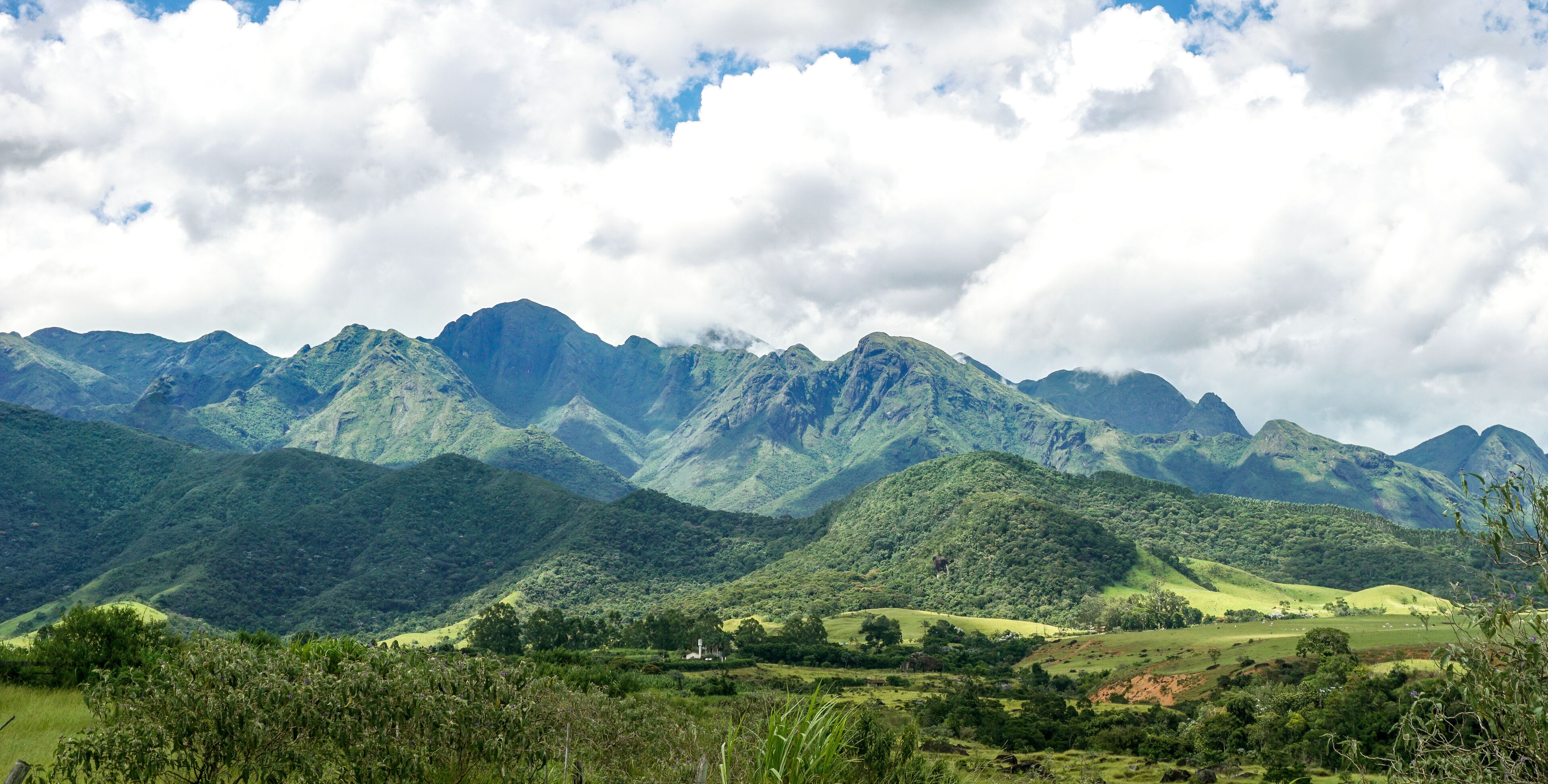 A mountainous landscape with lush green hills and a church in the valley.
