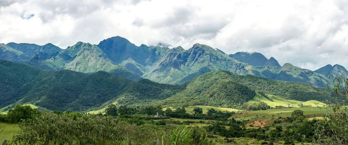A mountainous landscape with lush green hills and a church in the valley.