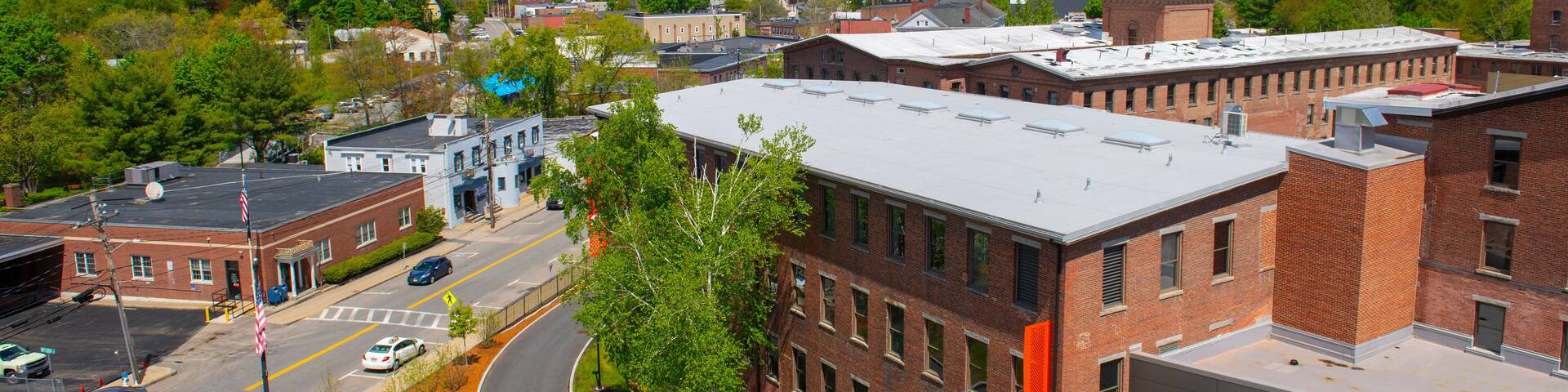 Historic Assabet Woolen Mill, built in 1847, on Main Street on Assabet River in Maynard historic town center in spring, Maynard, Massachusetts, USA.