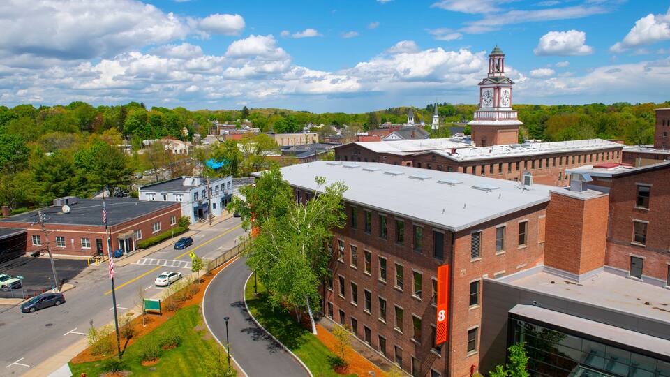 A town with a prominent clock tower, a curved road, and a mix of brick and modern buildings.