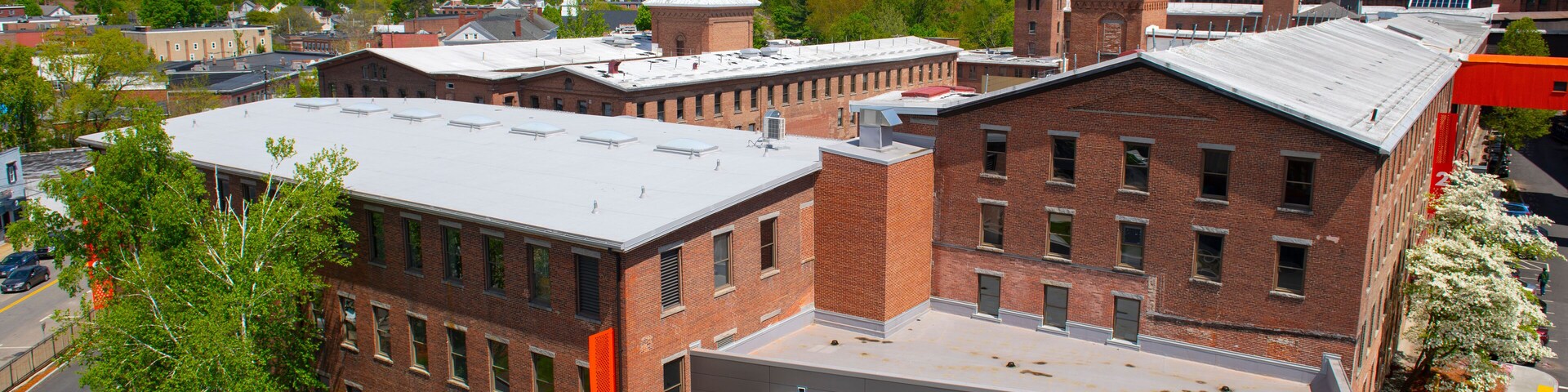 Historic Assabet Woolen Mill, built in 1847, on Main Street on Assabet River in Maynard historic town center in spring, Maynard, Massachusetts, USA.