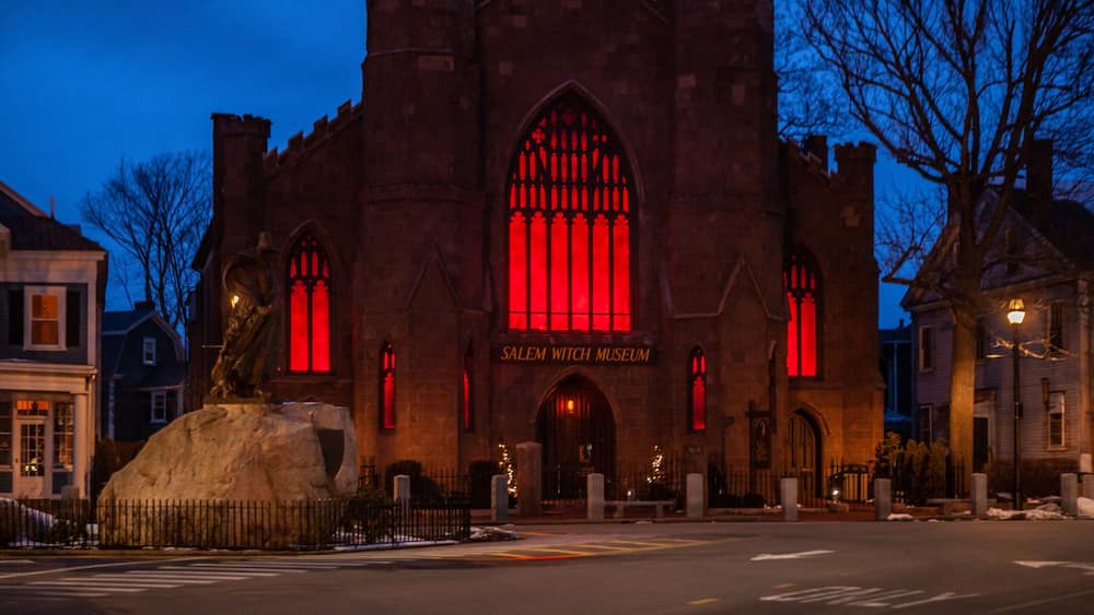 The Salem Witch Museum with a prominent red-lit window and Gothic architecture.