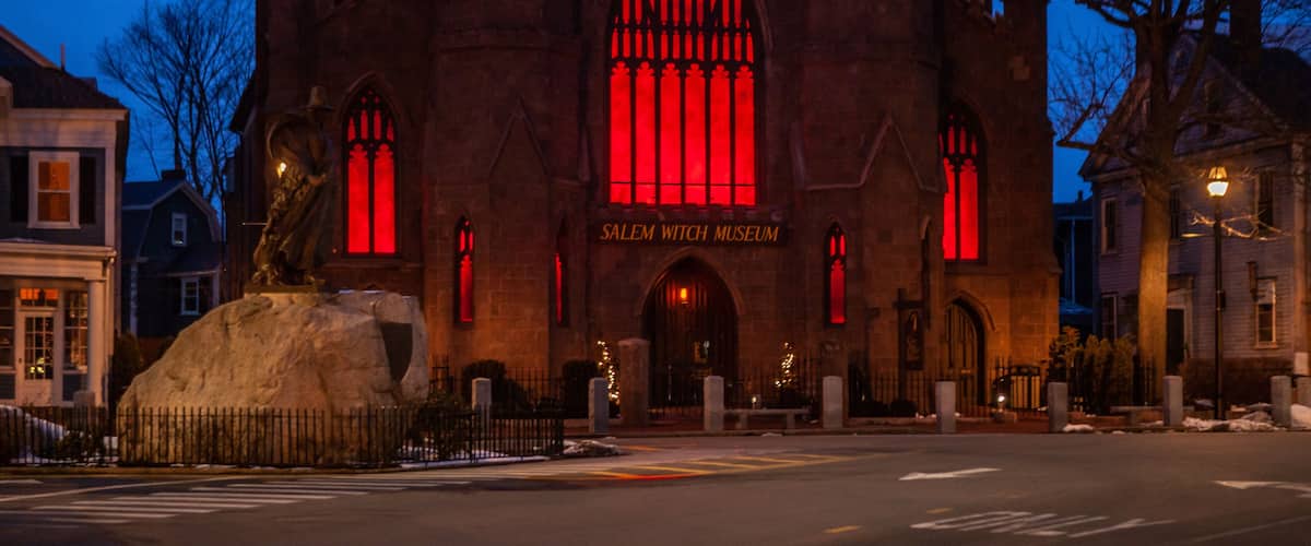 The Salem Witch Museum with a prominent red-lit window and Gothic architecture.