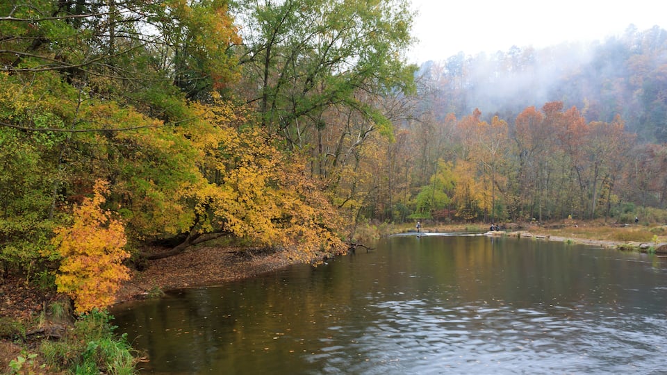 A calm river surrounded by autumn foliage.