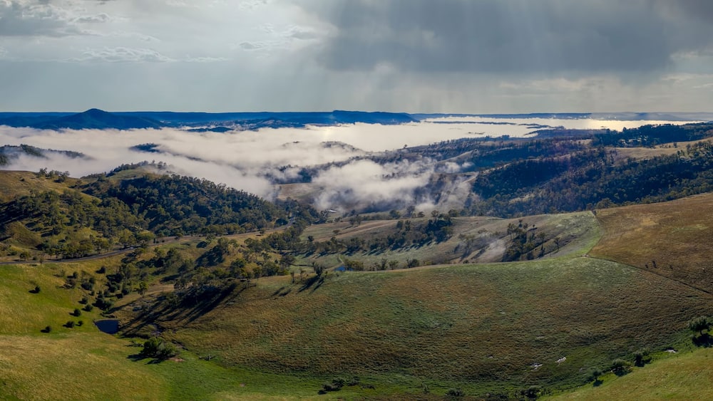 Aerial view of low-level clouds in a large green valley in regional Australia