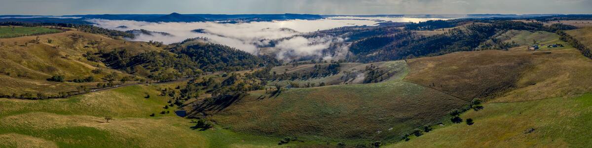 Aerial view of low-level clouds in a large green valley in regional Australia